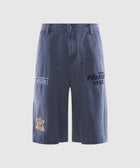 Men's blue denim shorts with embroidered patches and text, streetwear style