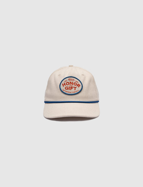 Beige baseball cap with embroidered HONOR GIFT patch, blue trim, streetwear style
