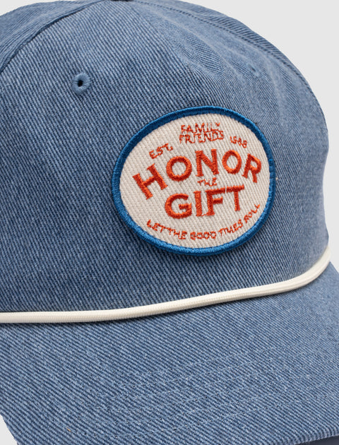Light blue denim cap with white piping and embroidered patch reading 'Honor The Gift'.