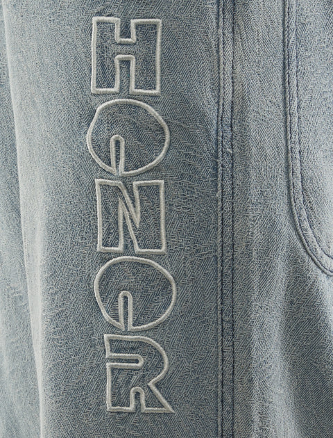 Light blue denim pants with HONOR embroidered in white on the leg