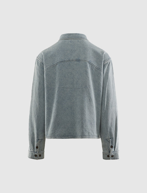 Back view of a light blue denim jacket with buttoned cuffs and classic collar