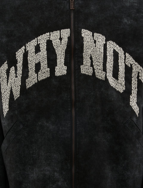 Black streetwear jacket with textured 'WHY NOT' lettering on chest, close-up view