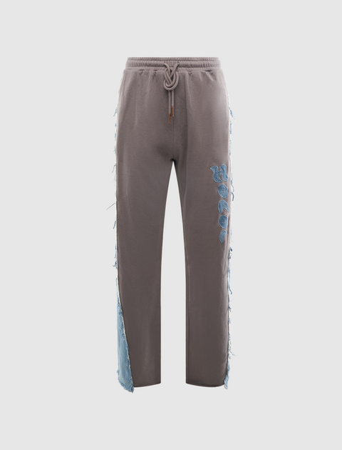Gray streetwear jogger pants with rope drawstring, blue applique, and denim frayed side panels