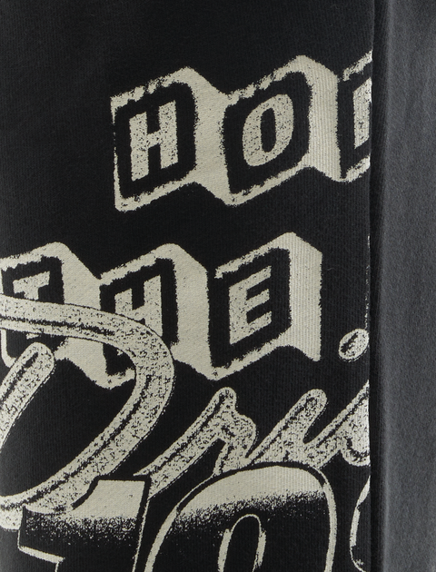 Close-up of black streetwear t-shirt with bold, vintage white graphic text print
