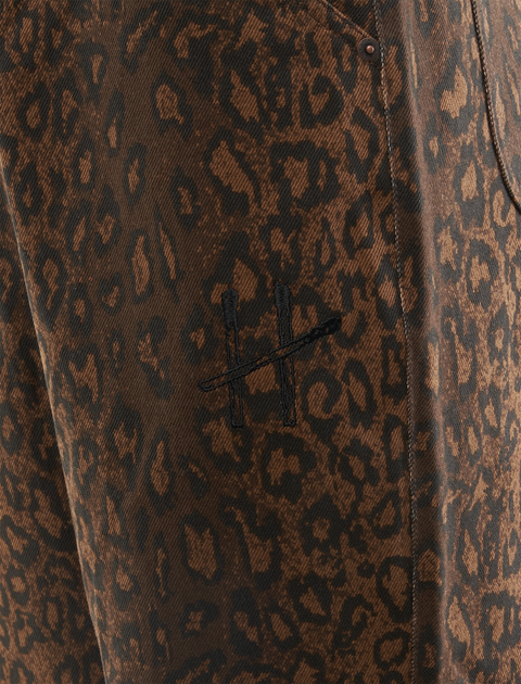 Close-up of brown leopard print men's pants with stitched cross logo detail