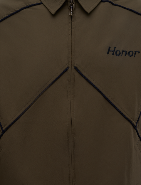 Close-up of brown zip-up jacket with navy piping and 'Honor' embroidered on chest