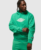 Man wearing a green Air Jordan hoodie and sweatpants with Nike patch on sleeve.
