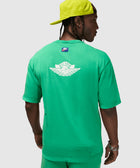 Man wearing green Nike Air t-shirt and shorts set, with lime green cap, shown from the back