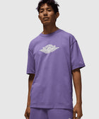 Man wearing a purple Air Jordan t-shirt and shorts set with logo on chest and leg