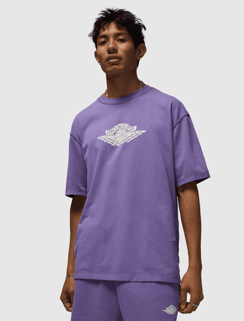 Man wearing a purple Air Jordan t-shirt and shorts set with logo on chest and leg