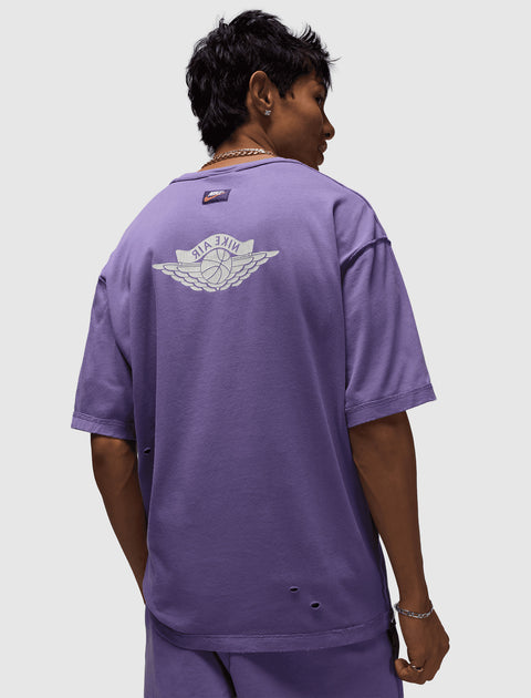 Man wearing purple Nike Air t-shirt with back logo and distressed details