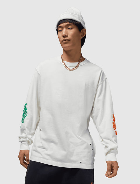 Man in white long sleeve streetwear shirt with colored sleeve graphics and white beanie