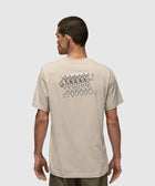 Back view of man in beige graphic streetwear t-shirt with cartoon skeletons print.