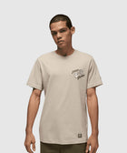 Man wearing beige streetwear t-shirt with chest graphic text and hand illustration
