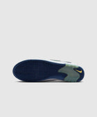 Blue wavy sole of a sneaker with yellow logo detail on a light grey background