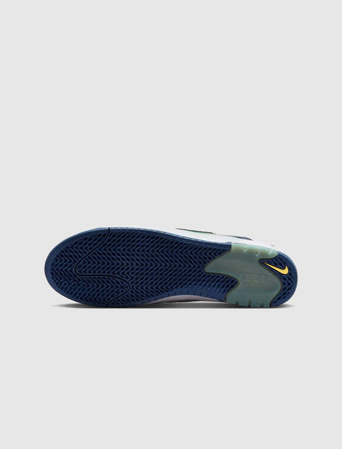 Blue wavy sole of a sneaker with yellow logo detail on a light grey background