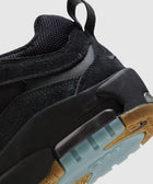 Close-up of black suede and mesh sneaker with gum sole and blue translucent outsole