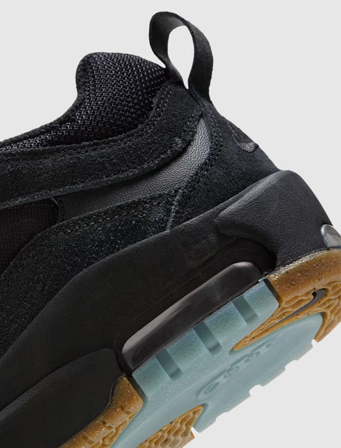 Close-up of black suede and mesh sneaker with gum sole and blue translucent outsole