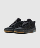 Black low-top sneakers with suede and leather details, gum sole, and visible air cushioning