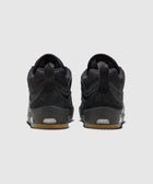 Back view of black skate sneakers with gum soles on a light background