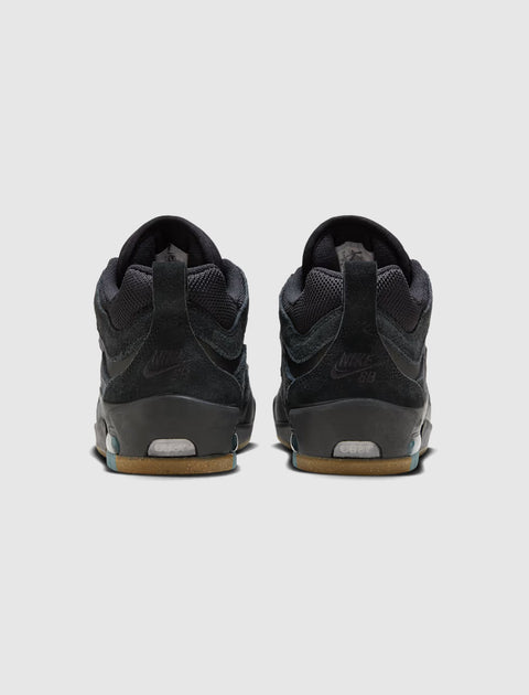 Back view of black skate sneakers with gum soles on a light background
