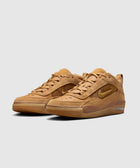 Tan suede low-top sneakers with gum soles and side swoosh logo on a light background