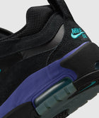 Close-up of black suede and mesh sneaker with teal Nike SB logo and purple accent