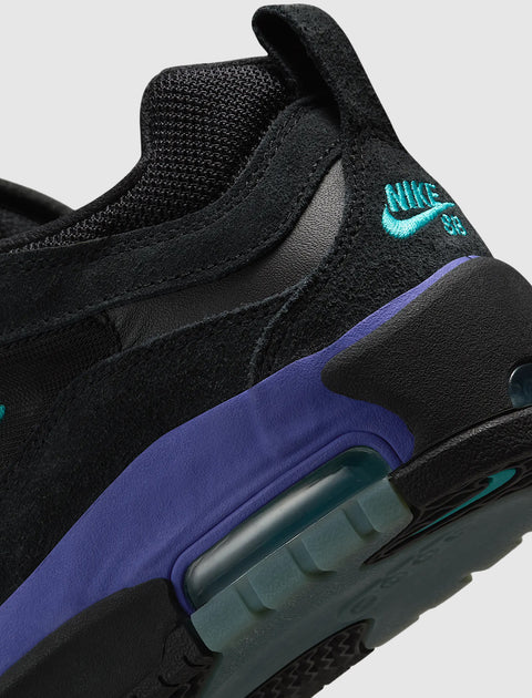 Close-up of black suede and mesh sneaker with teal Nike SB logo and purple accent