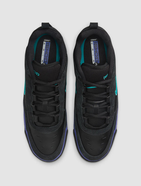 Top view of black sneakers with teal accents and purple trim against a light background.