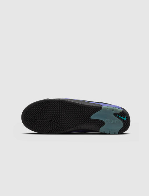 Black sneaker outsole with teal accents and herringbone traction pattern on light gray background