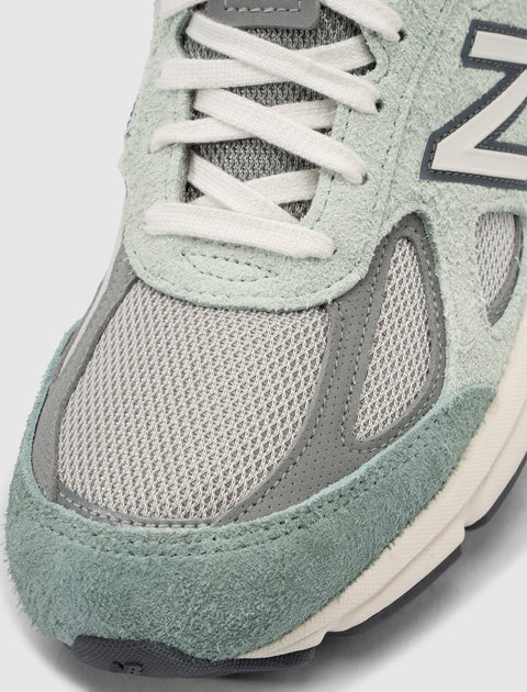 Close-up of a grey and mint green mesh and suede sneaker with white laces