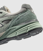 Close-up of green and grey suede and mesh sneaker with '990' and ENCAP midsole details