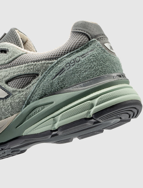 Close-up of green and grey suede and mesh sneaker with '990' and ENCAP midsole details