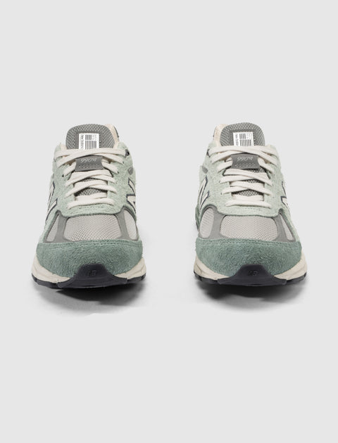 Pair of grey and mint green suede mesh sneakers with white laces, front view