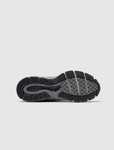 Close-up of New Balance sneaker sole with textured tread pattern on light background.