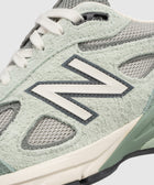 Close-up of mint green suede and mesh sneaker with white laces and textured midsole