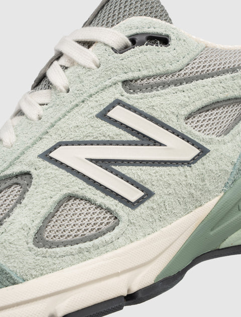 Close-up of mint green suede and mesh sneaker with white laces and textured midsole