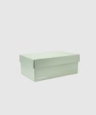Closed mint green New Balance sneaker box on white background