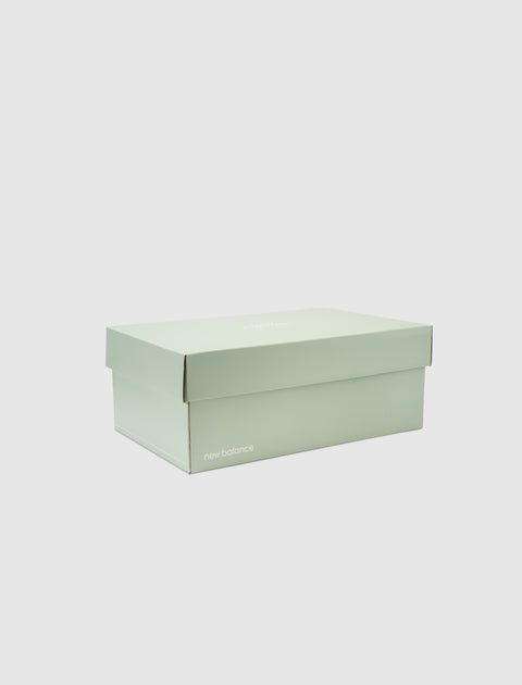 Closed mint green New Balance sneaker box on white background