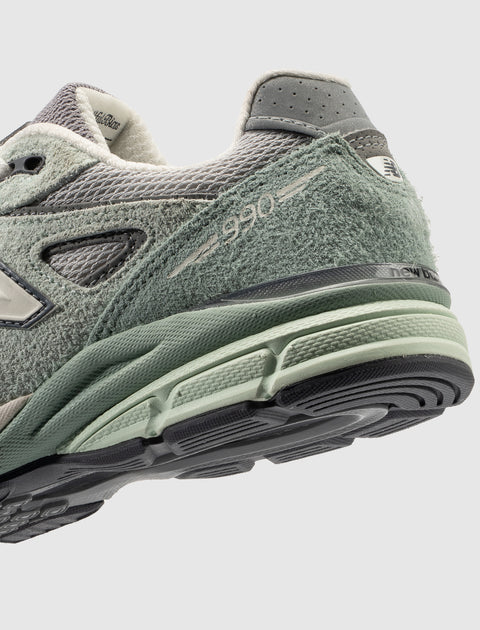 Close-up of mint green and grey suede men's sneaker with 990 logo and textured sole