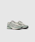 Men's grey and green New Balance sneakers with mesh and suede details on white background