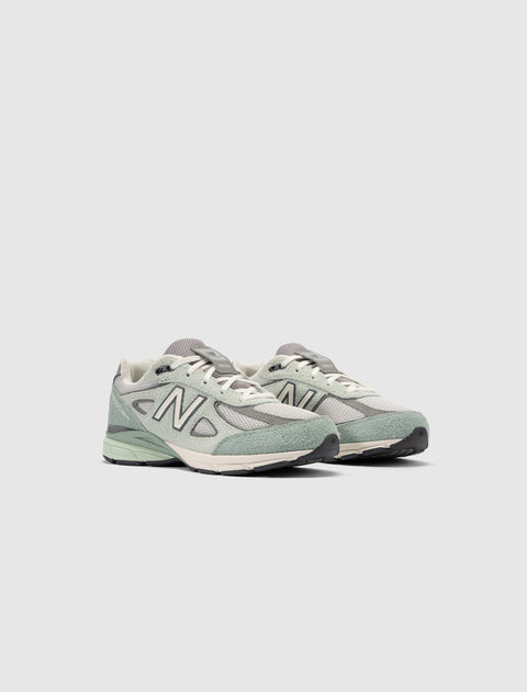 Men's grey and green New Balance sneakers with mesh and suede details on white background