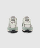 Pair of New Balance 990v4 sneakers in grey and mint green suede, front view on white background