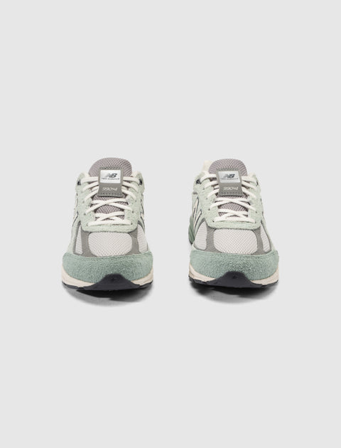 Pair of New Balance 990v4 sneakers in grey and mint green suede, front view on white background