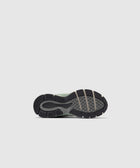 Close-up of a sneaker outsole with textured grip and New Balance logo on a light background