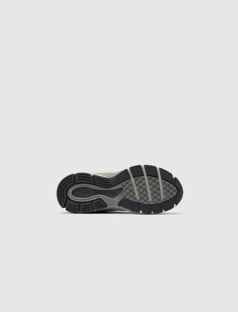Close-up of a sneaker outsole with textured grip and New Balance logo on a light background