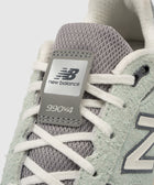 Close-up of New Balance 990v4 sneaker in grey mesh and suede with white laces