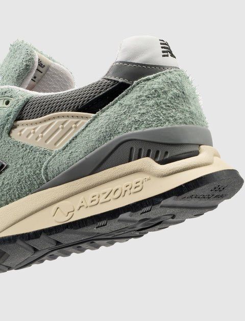 Close-up of textured green suede sneaker heel with ABZORB sole on light background