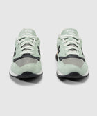 Pair of mint green and grey suede mesh sneakers with white laces, front view