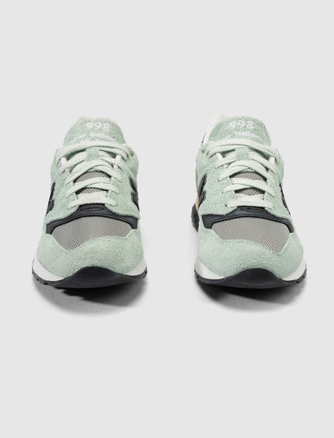 Pair of mint green and grey suede mesh sneakers with white laces, front view
